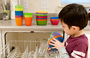 Young boy unloading a dishwasher