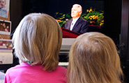 Two little girls watching General Conference on TV