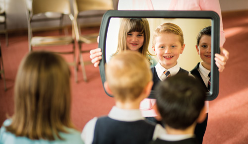 Kinder schauen in einen Spiegel